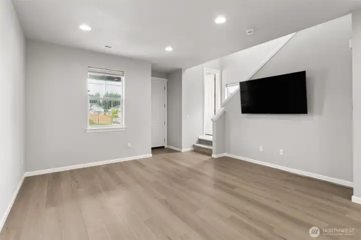 Living room located between front entry & kitchen area. Powder room is to the right & located up the two stairs.
