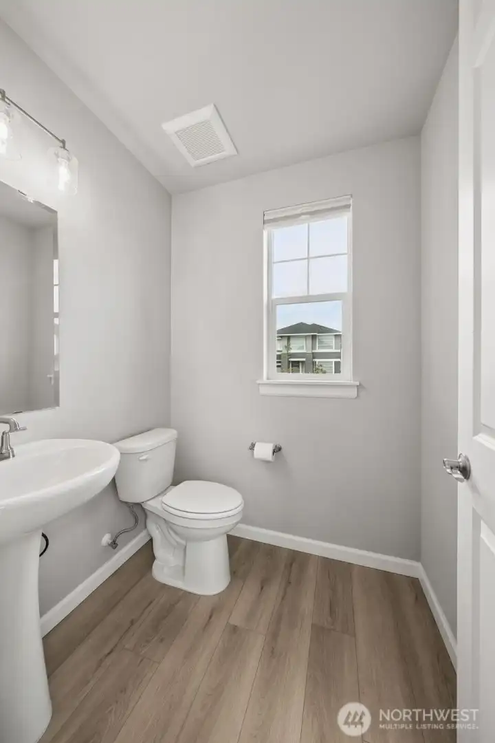 Powder room located on main level with LVP flooring.