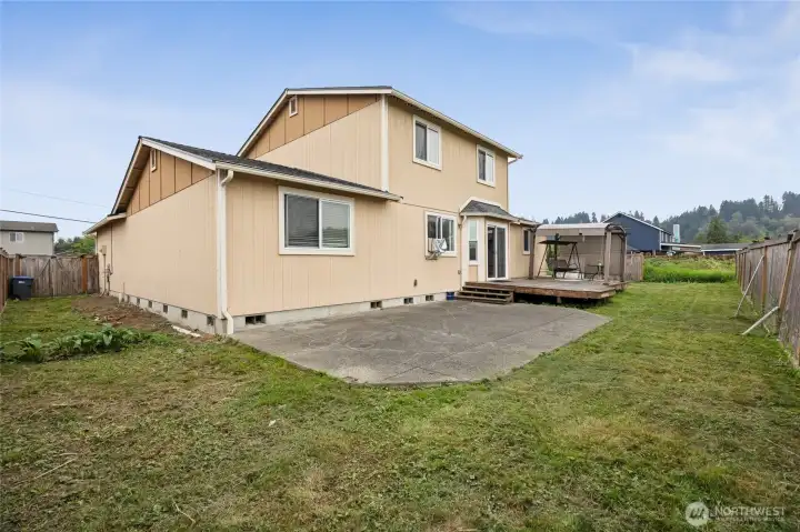 Back yard with patio, and deck with a pergola style cover.
