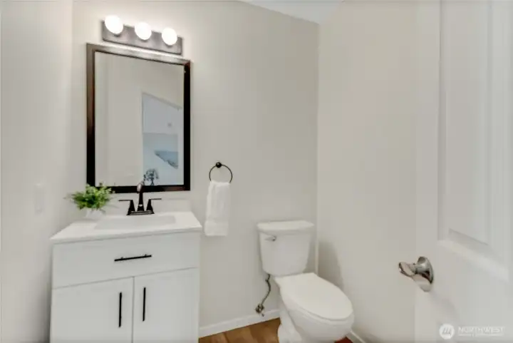 This cute half bath next to the office has a new vanity, new toilet, and of course new paint and flooring!