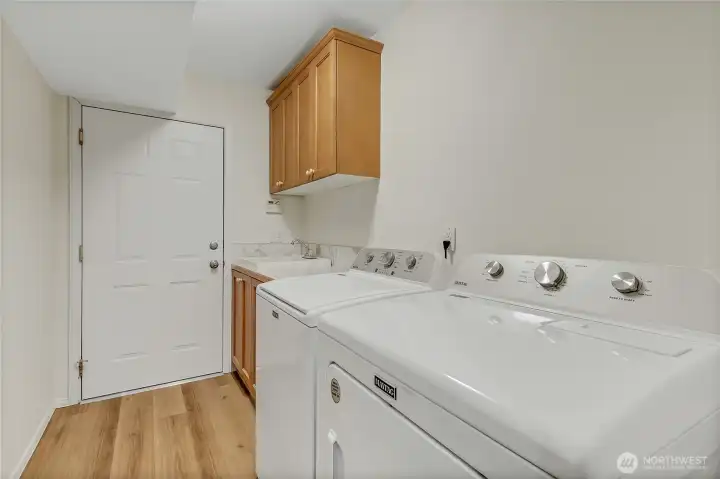 Main floor laundry room sits next to the garage and includes the washer and dryer! Has a deep sink new counter and backsplash as well