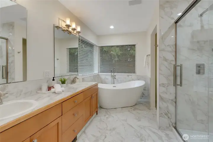 Welcome to this gorgeous primary bath that has been refreshed with all brand new porcelain tiles, new sinks, new lighting,new large tub, beautiful new shower enclosure and a new toilet as well! Room is filled with natural light from the large corner windows!