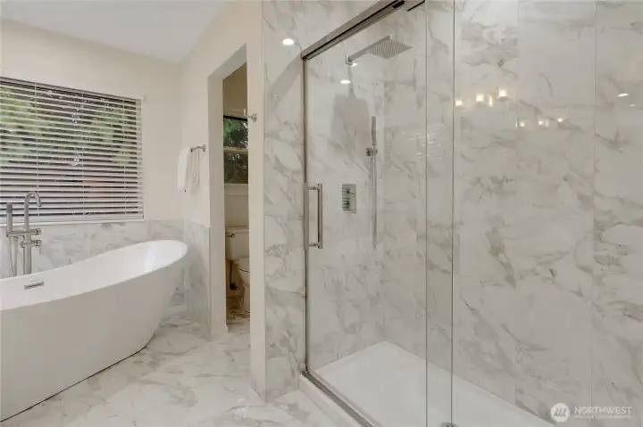 Another angle of the primary bath to include the fabulous new tile shower enclosure with a soft closing pivot door. New toilet in the back room as well. This room also has tall ceilings with a large skylight!
