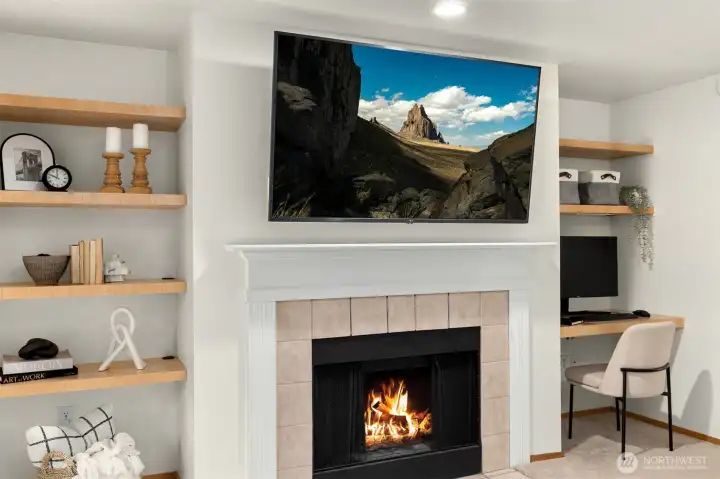 Built in shelving and a built in desk around the wood burning fireplace.