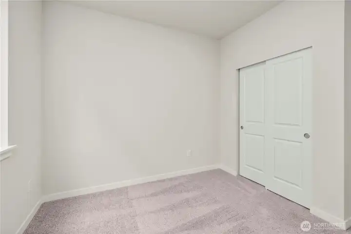 Main level bedroom. Photos of a previously completed home. Actual colors and finishes may vary. See site agent for details.