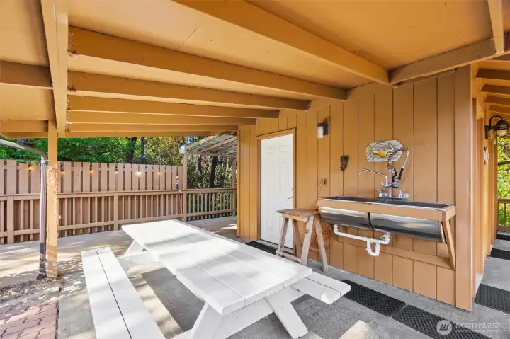 ---a covered outdoor picnic/crab or clam cleaning area is --