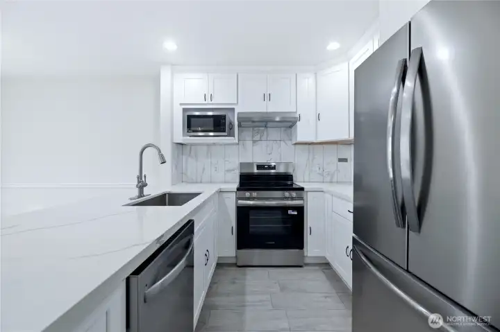 Recently Remodeled Kitchen with Stainless Steel Appliances, Quartz Counters & Tile Backsplash
