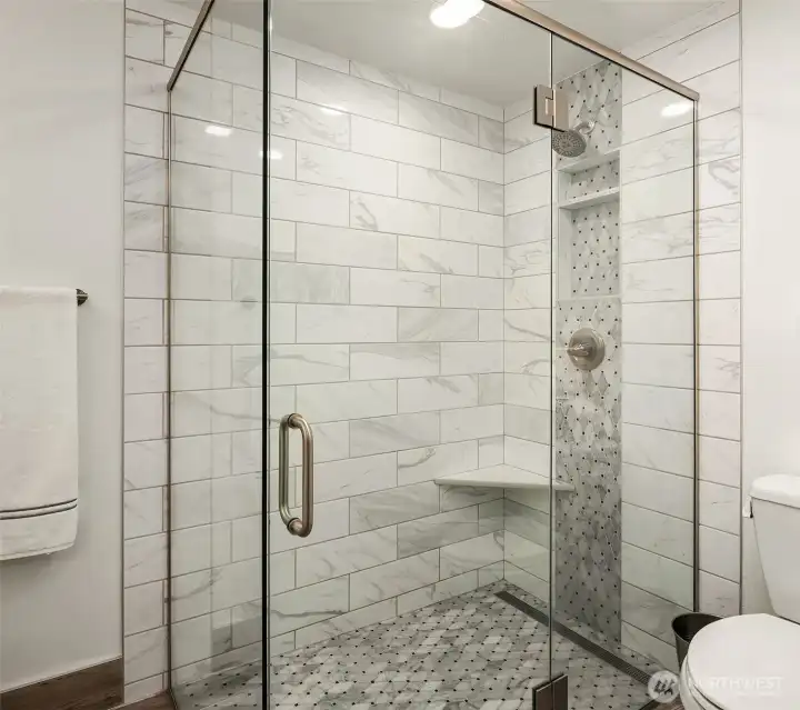 Updated primary suite bath custom shower with integrated wall niches and high end toilet. Updated primary suite bath custom shower with integrated wall niches and high end toilet.