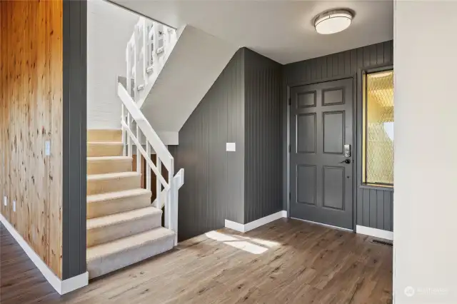 Entryway with stars up to extra bedrooms and down to the partially finished basement.