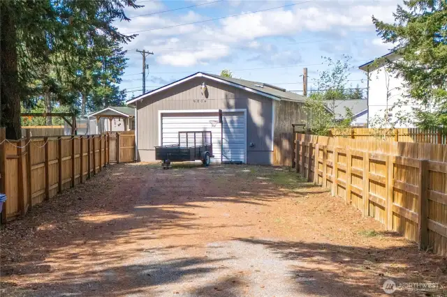 Long and wide driveway leads to 832 sqft garage with shop. Fence has 2 gates. Garage has RV electrical hookup