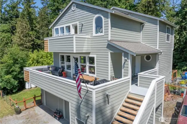 Main level entrance, entertainers deck, and private primary balcony.