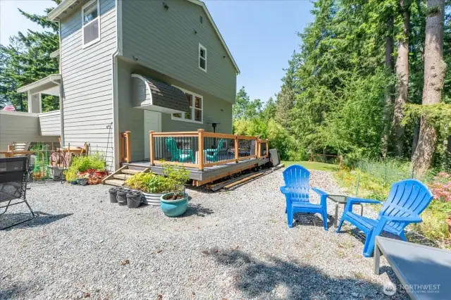 Expansive fenced in backyard with fire pit.