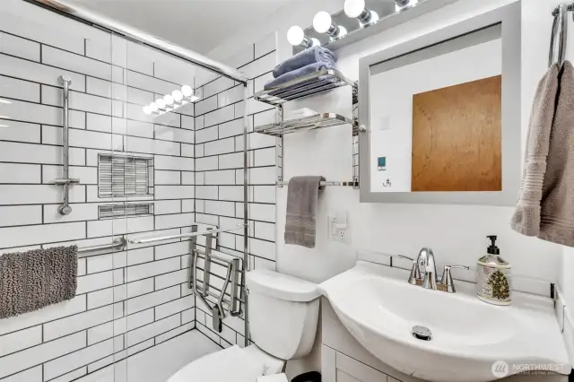 Remodeled bathroom with heated floors and pull down seat in the roomy shower.