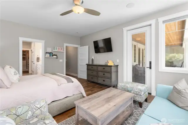 Primary bedroom with access to patio, natural light beams in through the large windows