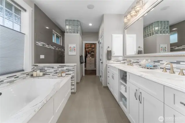 Primary ensuite bathroom with radiant heated floors, double sinks, walk-in shower, and large soaking tub.
