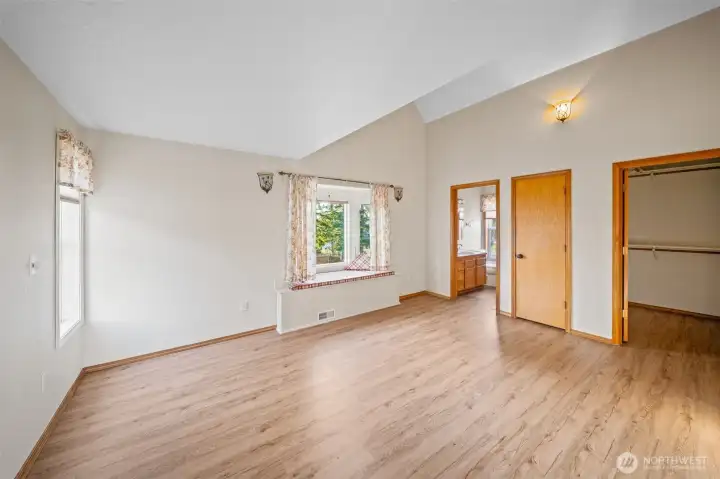 Upstairs is another, original primary suite. It gets beautiful light and is airy, with a vaulted ceiling and charming window seat looking at the lake. Large walk in closet, additional closet and an ensuite bath round out the package