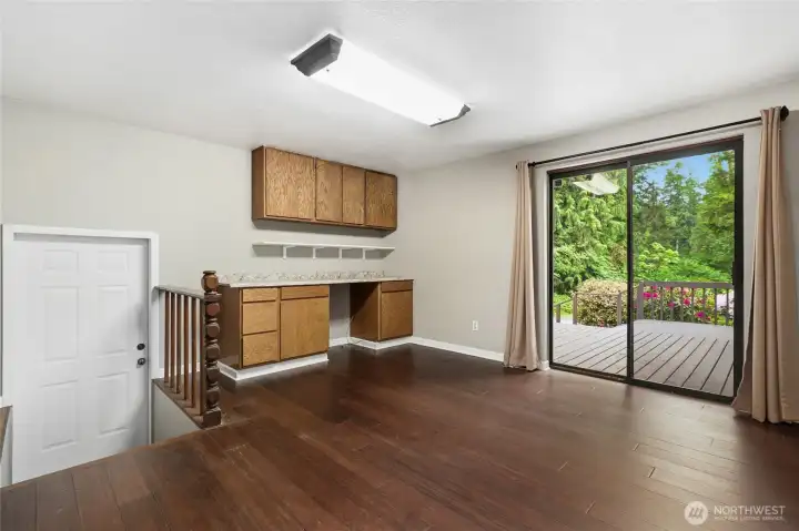 Den/ Office space located near the primary bedroom. Access to the front deck on the right and entrance to the massive shop on the left.