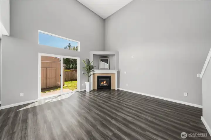 Bright and spacious living area with vaulted ceilings and cozy fireplace