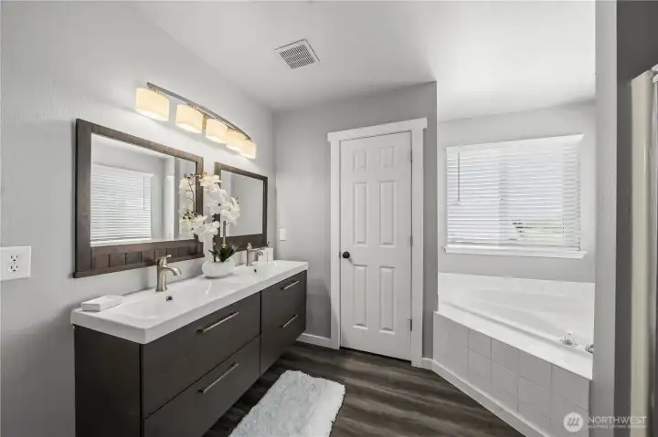 Spacious main bathroom with double vanity, soaking tub, and plenty of natural light, toilet separate for added privacy