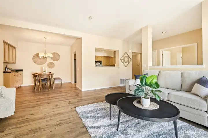 Open-concept living and dining areas featuring durable laminate plank flooring and abundant natural light. Open-concept living and dining areas featuring durable laminate plank flooring and abundant natural light.