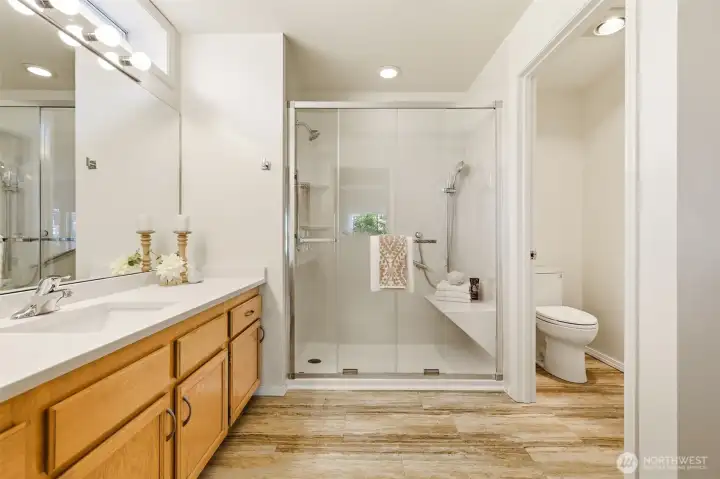 Oversized Jacuzzi walk-in shower with built-in bench, grab bars, and private water closet. Oversized Jacuzzi walk-in shower with built-in bench, grab bars, and private water closet.