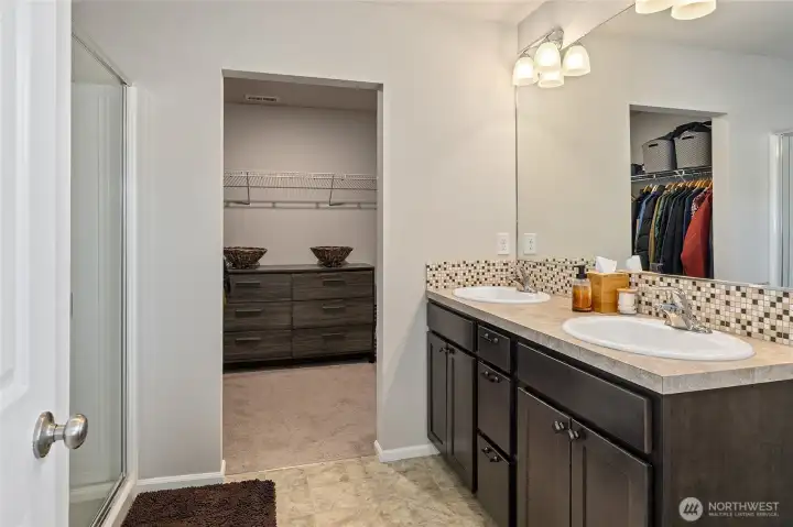 primary bath with a walk in shower and large walk in closet.