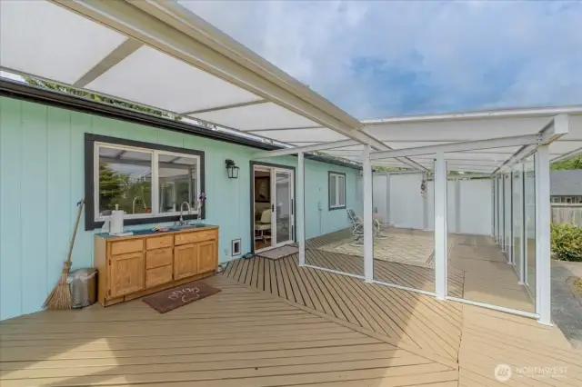 Large deck with glass awning covering.