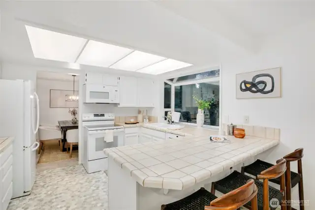kitchen opening to casual dining area & den w/ backyard access