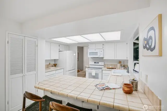 kitchen opening to casual dining area & den w/ backyard access