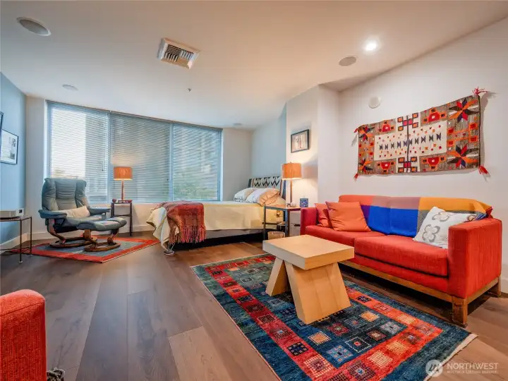 Open plan studio with wall of windows facing courtyard