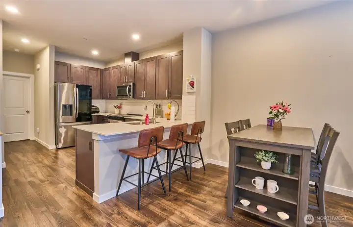 Dining area with large kitchen, stainless steel appliances and quartz counter tops.