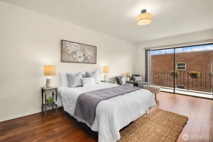 Spacious primary bedroom with seating area and deck