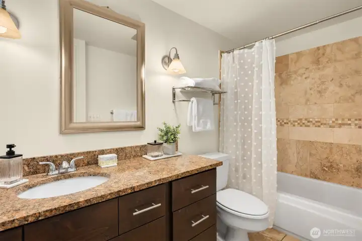 Full bathroom with travertine floors and shower surround