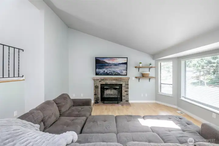 Living room is nice and bright and has a wood fireplace.