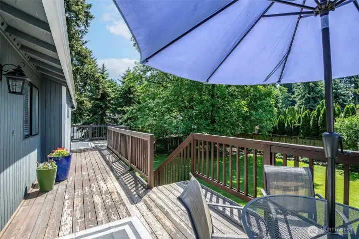 Full deck, stairs leading to fenced backyard.