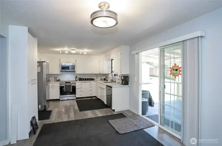 View from the dining area into the kitchen, creating an open and connected living space. The sliding glass door provides easy access to the back patio, perfect for indoor-outdoor living and entertaining.