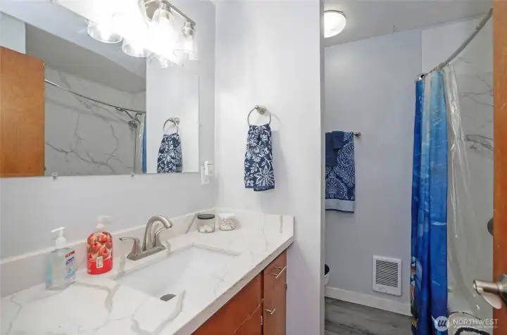 Full guest bathroom with Full guest bathroom featuring quartz countertops and a clean, modern finish.Quartz counters.