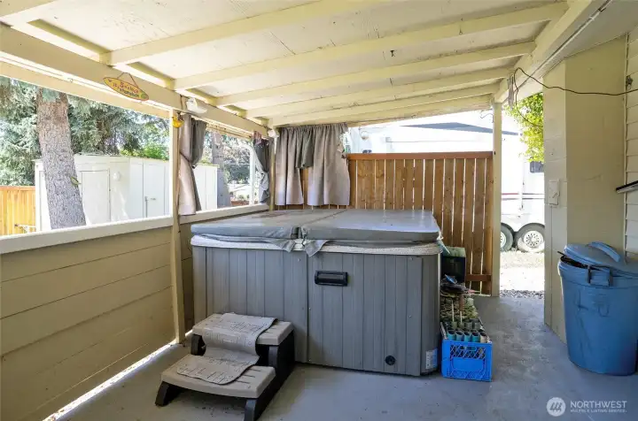 Covered back patio with access to the side yard, complete with RV hookup for added convenience.