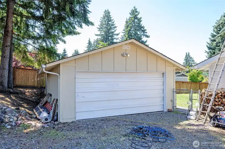 Closer view of the detached garage with a gated entry providing access to the backyard.