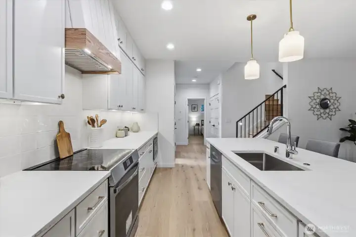 Induction range and quartz countertops with undermount stainless sink. Induction range and quartz countertops with undermount stainless sink.