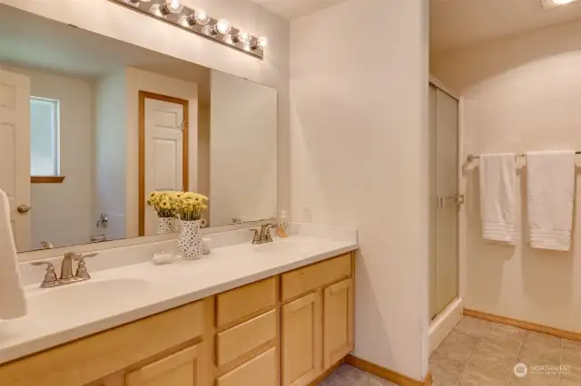 Primary Bathroom with double sinks, separate shower and tub area, as well as linen closet