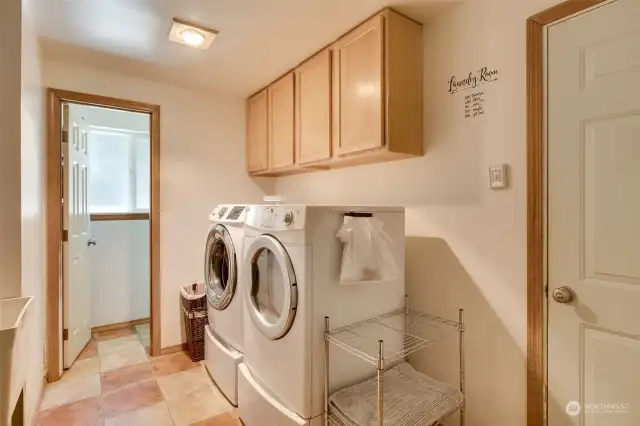 Utility room has built in cabinets, tile floors, soaking sink, water closet & leads out to garage
