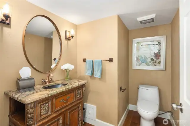 Located on the main level is a powder room for guests, featuring a custom-made vanity that contributes to the luxurious feel of the home.
