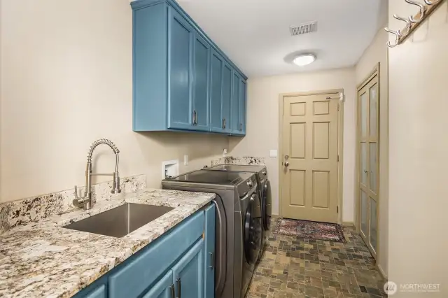 This home boasts a spacious laundry room with luxury upgrades. One of the nicest features is the high-end slab stone countertops, ideal for folding clothes or serving as a workspace.