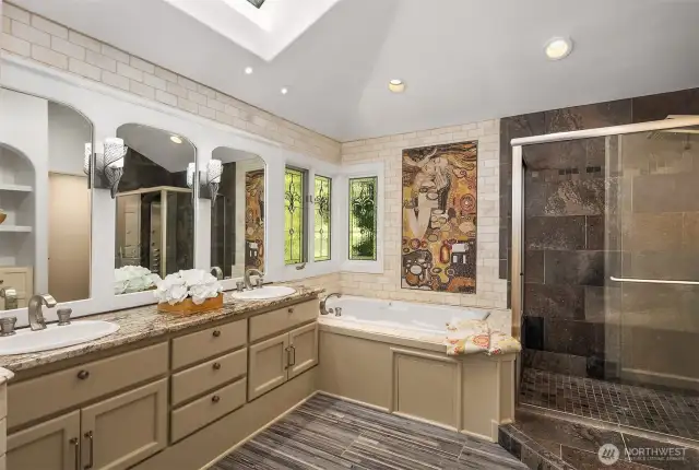 Indulge in spa-like luxury with this elegant primary bathroom featuring dual vanities, a soaking tub, custom stained glass, and a one-of-a-kind mosaic inspired by Gustav Klimt’s The Kiss.