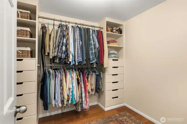 The primary suite has a walk-in closet, complete with built-in shelves and drawers for better organization.