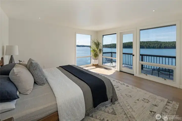 Wake up to panoramic water views from this beautifully appointed primary suite, complete with floor-to-ceiling windows and direct access to the waterfront deck. Thoughtful minimalist styling highlights the breathtaking scenery as the focal point.