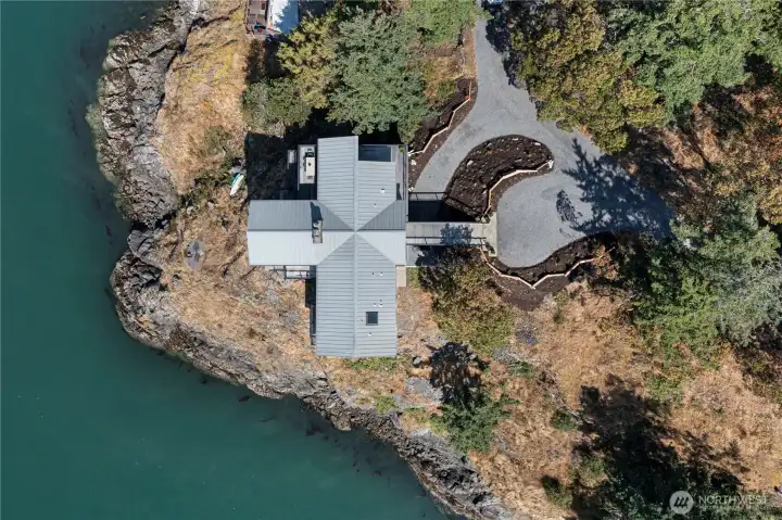 A true bird’s-eye view captures the home dramatically set atop a rocky point, offering total privacy and unobstructed waterfront scenery. The extensive shoreline and thoughtful placement of the residence highlight its premier Orcas Island location.