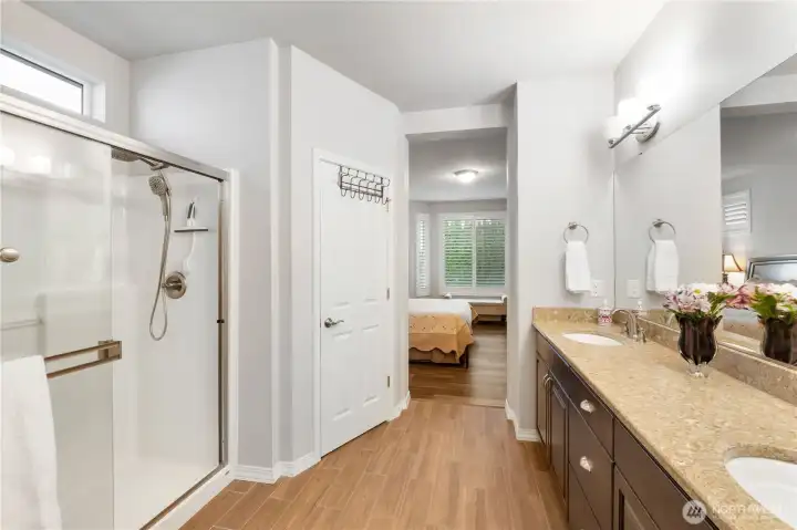 Safe step-in shower in the primary bathroom plus huge vanity and double undermount sink, of course. Transom window above the shower brightens the room naturally. Huge walk-in closet too (not in photograph).