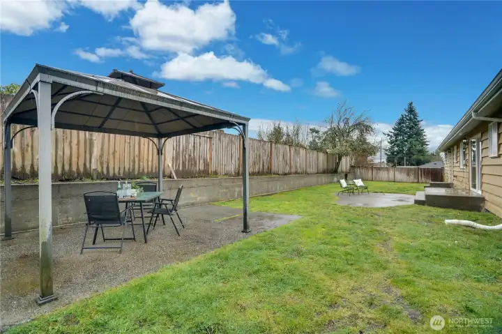 Fenced backyard with two patio spaces. Gazebo conveys with home.